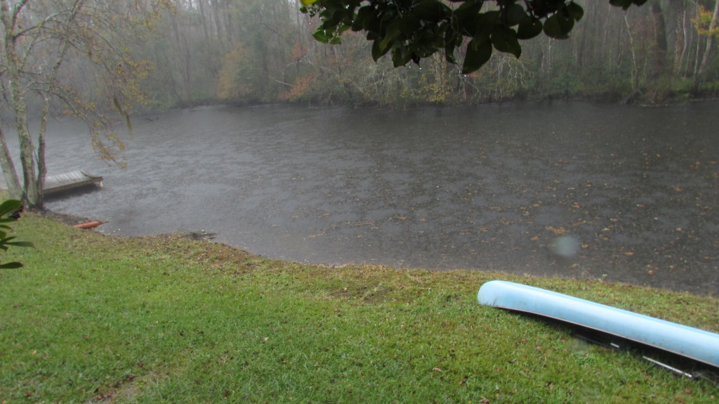 A blue canoe on a storm lawn.