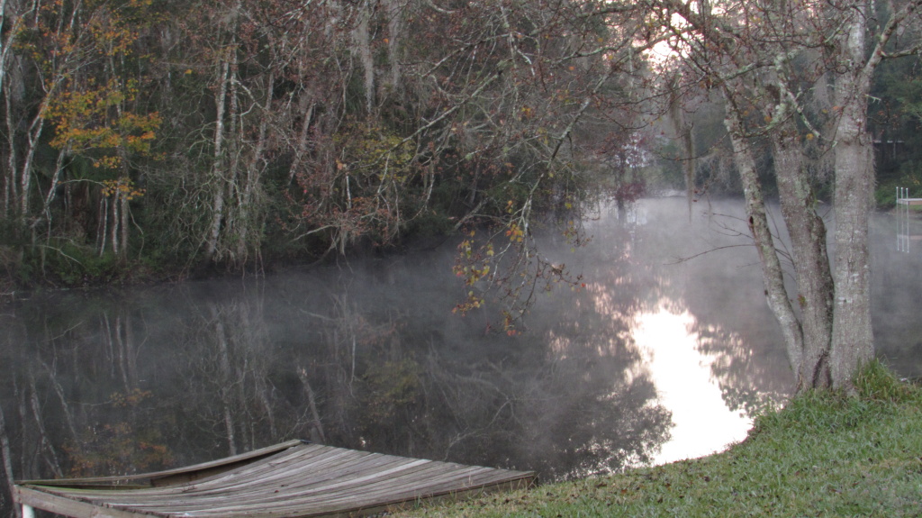 Looking out over the fog covered dock and water as the sun comes up.